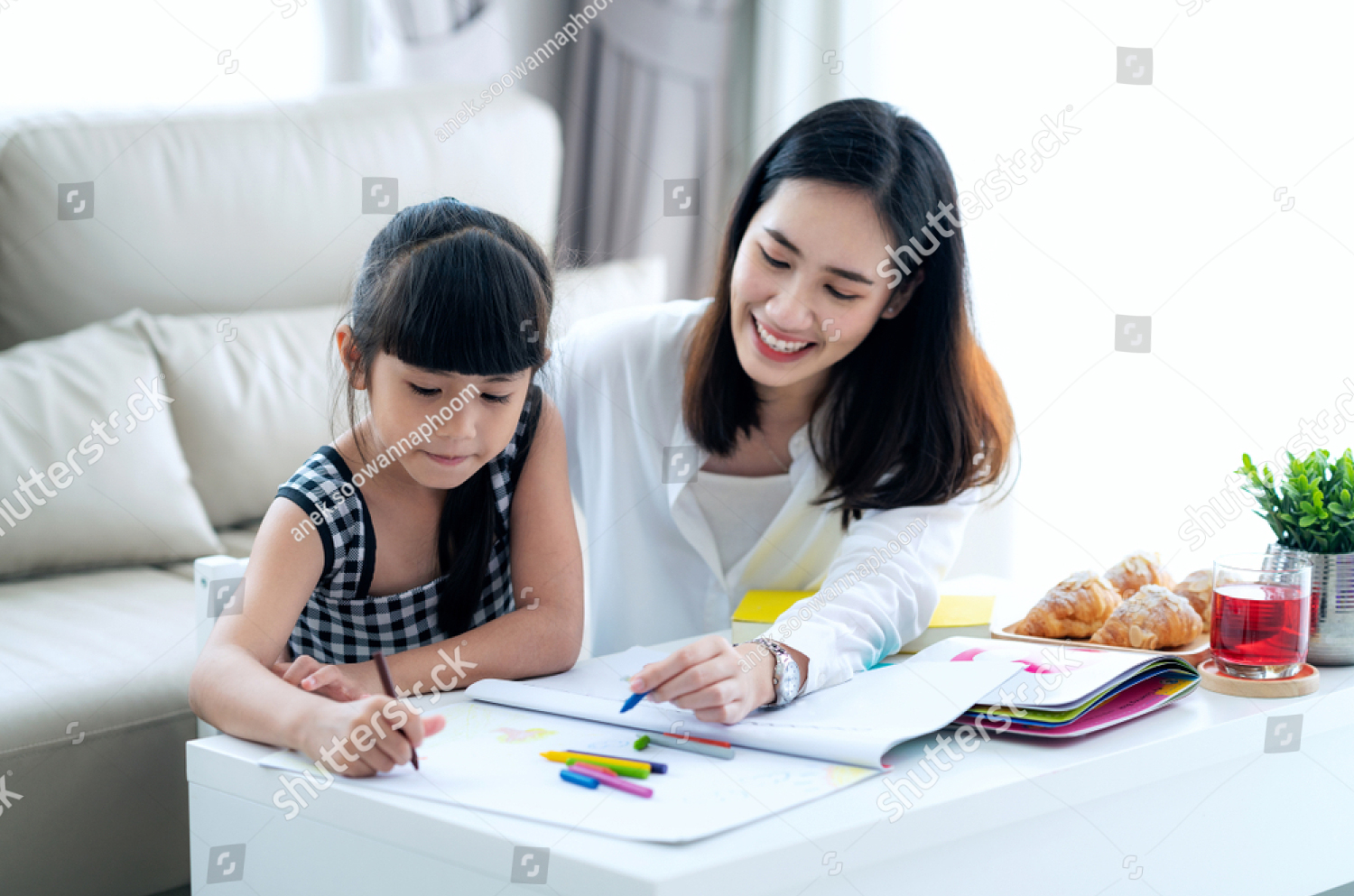 Woman helping child with project